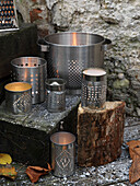 Lit candles in metal tins with a log of firewood Brighton, East Sussex UK