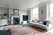 Plexiglas-Couchtisch mit Sofa und Teppich mit Cello am Kamin in einem Haus in Winchester, Großbritannien