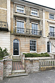 Vorderer Weg und Türöffnung mit Balkongeländer an der Außenseite eines 3-stöckigen Stadthauses in Winchester UK