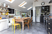 Wooden table and chairs with black fitted kitchen in spacious open plan Reading kitchen Berkshire England UK