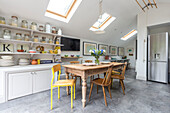 Vorratskammer für getrocknete Lebensmittel mit Holztisch und Stühlen unter Dachfenstern in der Küche von Reading, Berkshire, England UK