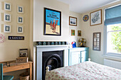 Artwork above fireplace with roman blinds at window in bedroom of Reading home Berkshire England UK