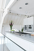 Open plan kitchen with polished concrete surfaces in converted Courthouse London UK