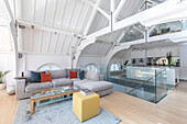 Light grey sofa in open plan living room of converted London courthouse UK