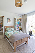 Oak bed and bookcases with guitar in sustainable newbuild Highgate London UK
