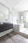 Weißes Badezimmer mit großem Spiegel und Duschabtrennung in einem nachhaltigen Neubau in Highgate, London, UK