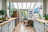 Green glassware on worktops in kitchen extension of Victorian terrace Alton UK