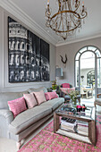 PInk hues and artwork with glass chandelier in living room of Victorian terrace Wandsworth London Uk