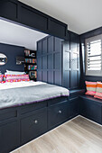 Built in bed with panelling and bookshelves in Victorian terrace Wandsworth London Uk