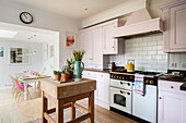 Spring bulbs on butchers block in open plan kitchen of Guildford cottage Surrey UK