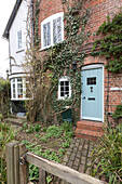 Ivy grows on brick exterior of Victorian farm workers cottage in Guildford Surrey UK