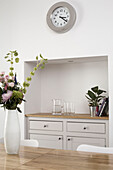 Sideboard in recessed alcove of dining room with cut flowers