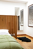 Black sheepskin rug on floor of contemporary bedroom with headboard partition