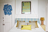 Poster above bed with fairylights and Hawaiian shirt with checked headboard