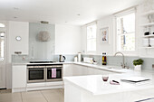 White kitchen with grey splashback and double oven
