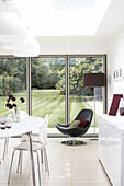 Kitchen extension with black leather chair and view through doors to back garden