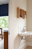 En suite bathroom with his and hers mounted cabinets in London home