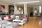 White painted coffee table with grey corner sofa in open plan living room of Sydney home Australia