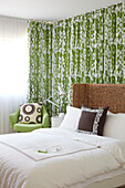 Grüne Blumenvorhänge und ein Kopfteil aus Naturfasern in einem Sommerschlafzimmer in einer Wohnung in Sydney, Australien