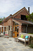 Patio terrace of brick and stone Somerset barn conversion exterior England UK