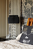 Grey leaf motif cushion and black bedside lamp in Somerset barn conversion England UK