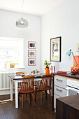 Wooden chairs at sunlit kitchen table in Isle of Wight home UK