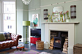 Cut flowers on mantlepiece of light green living room in Scottish apartment building UK