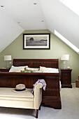 Antique wooden bed in attic conversion of Bembridge beach house, Isle of Wight, England, UK