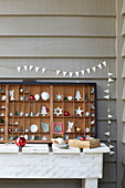 Christmas decorations on wooden shelving unit with bunting in Isle of Wight home, UK