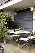 Folding chairs at table on terrace with grey shutters semi-detached home UK