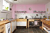 Stainless steel and wood units in pink kitchen with single word FOOd semi-detached home UK