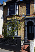 Backsteinfassade eines Londoner Reihenhauses mit schwarzem Anstrich, England, UK