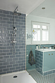 Grey tiled shower cubicle in panelled London bathroom, England, UK