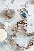 Paint tubes with necklace of seashells in Bembridge houseboat Isle of Wight, UK