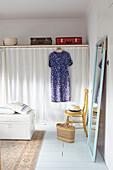Vintage suitcases above curtained wardrobe with blue dress in Ryde bedroom Isle of Wight, UK