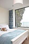 Teddybear on double bed at window in modern Isle of Wight home UK