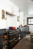 Schwarze Küche mit Kopfsteinpflasterboden in einem Stadthaus in Hastings, East Sussex, England, UK