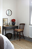 Vintage wooden chair at table with coir rug in bedroom of Brighton home East Sussex UK