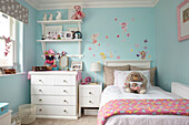 Wall mounted shelves and chest at bedside with toys in girl's room painted ?Chance? Buckinghamshire UK