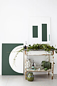 Zinc-topped table with seasonal foliage green glassware and geometric artwork