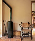 Modern country living room close up showing wood burning stove and wicker chair in the shaker style