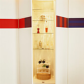Wall with concealed storage and painted frieze decoration opening into illuminated drinks cabinet