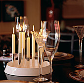 Gläser und brennende Kerzen auf einem Esstisch