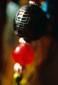 Detail einer Vorhanggarnitur mit schwarzer geschnitzter chinesischer Perle und roter Glasperle