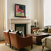 Leather armchairs by fireplace in living room