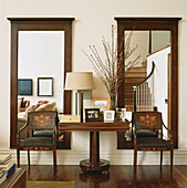 Pair of large mahogany mirrors on wall with Biedermeier chairs and console table