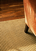Chair leg and silk linen rug detail on walnut floor