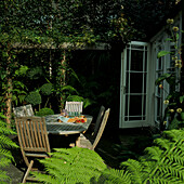 Shady patio garden setting with slatted wooden furniture