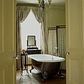 Reproduction Victorian cast iron roll top bath in elegant bathroom
