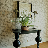 Side table in wallpapered hallway